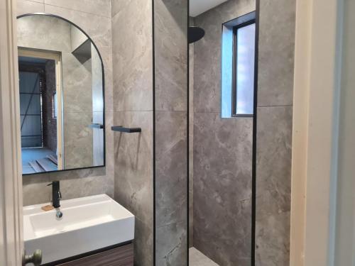 a bathroom with a sink and a mirror at The Breakers - Bunga Street 49 in Bermagui