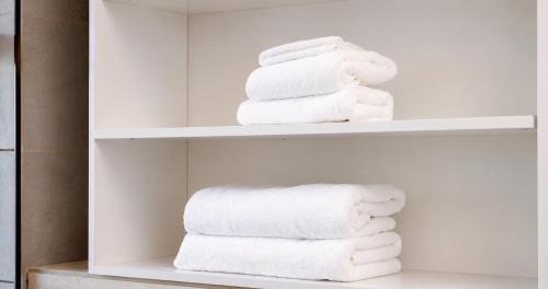 a pile of towels on shelves in a bathroom at Ras Hotel - Harar in Hārer