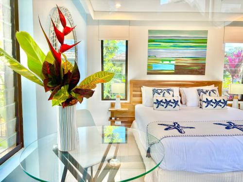a bedroom with a bed and a glass table at Paradise Escape - Poolside Ground Floor - Sea Temple Resort and Spa in Port Douglas