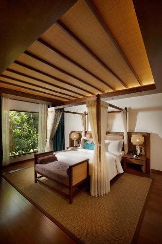 a bedroom with a large bed and a large window at The Leela Coorg Forest Sanctuary in Madikeri