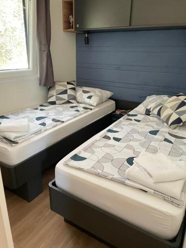 two beds sitting next to each other in a room at Mobile Home Drage Tara in Drage