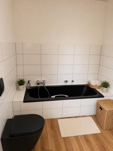 a bathroom with a black sink and a toilet at Mediterrane Ferienwohnung mit Whirlpool und Weitblick in Merchweiler