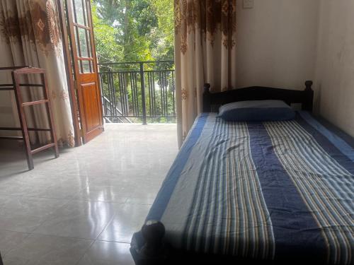 a bed in a room with an open door at Dissanayaka house in Nikawatawana
