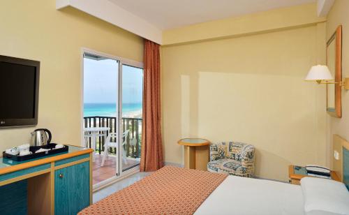 a hotel room with a bed and a balcony with the ocean at Sol Milanos Pingüinos in Son Bou