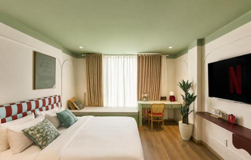 a bedroom with a large white bed and a desk at Elm Riverside Hotel by Urban B in Ho Chi Minh City