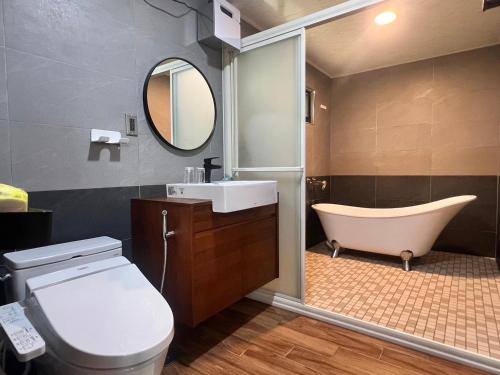 a bathroom with a tub and a toilet and a sink at 自在居森林民宿 in Wufeng