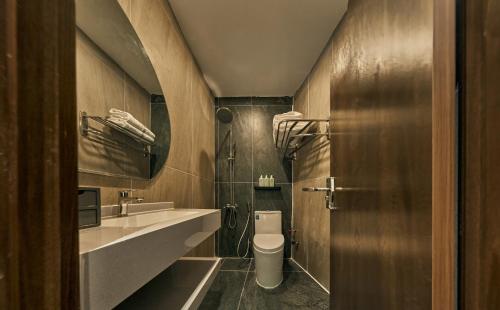 a bathroom with a toilet and a sink at Elm Riverside Hotel by Urban B in Ho Chi Minh City