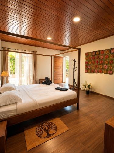 a bedroom with a large bed and a window at Lake House Mantasoa in Mantasoa
