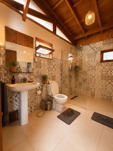 a bathroom with a toilet and a sink at Lake House Mantasoa in Mantasoa