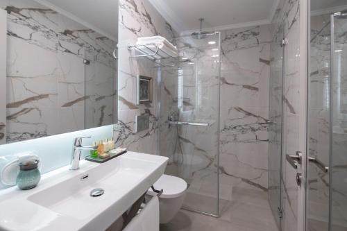 a bathroom with a sink and a shower at Akka Suites Taksim-Special Class in Istanbul