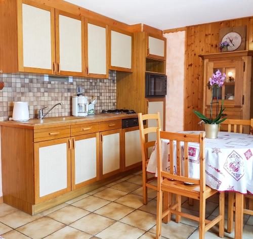 a kitchen with wooden cabinets and a table at Studio cosy à Les Gets 25 m² avec vue montagne in Les Gets