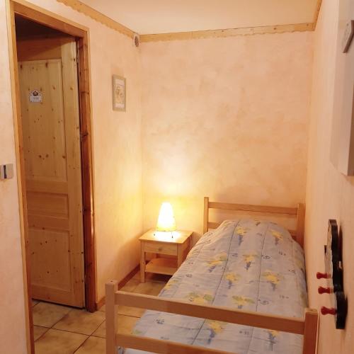 a small bedroom with a bed and a lamp on a table at Studio cosy à Les Gets 25 m² avec vue montagne in Les Gets