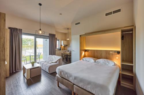 a bedroom with a bed and a living room at Holiday Suites Zeebrugge in Zeebrugge