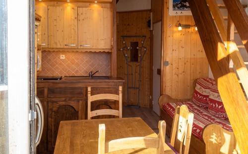 a kitchen and dining room with a table and a sink at Appartement charmant à Les Menuires, 36 m², vue montagne. in Saint-Martin-de-Belleville