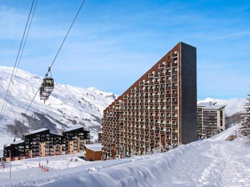 a building in the snow with a ski lift at Appartement charmant à Les Menuires, 36 m², vue montagne. in Saint-Martin-de-Belleville