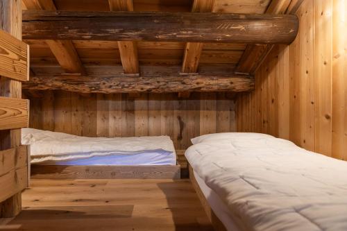 a room with two beds in a log cabin at Agriturismo Piccola Baita in Falcade