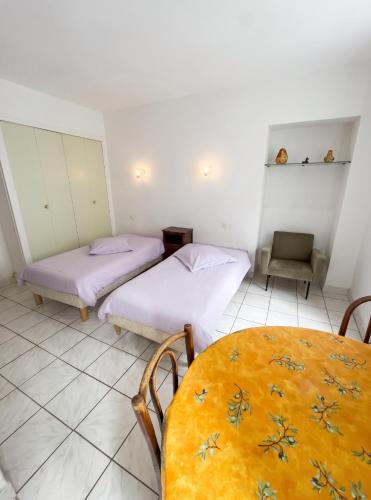 a room with two beds and a table in it at Charmant studio à Néris-les-Bains de 20 m² in Néris-les-Bains