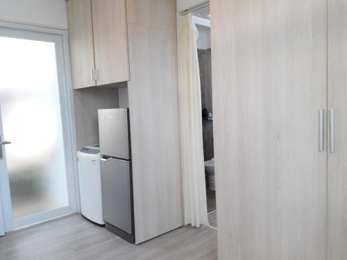 a white kitchen with a refrigerator and a door at TS Beach House in Phu Quoc