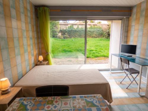 a bedroom with a bed and a desk and a window at Studio charmant dans Brioude – 25 m² avec terrasse et parking in Brioude