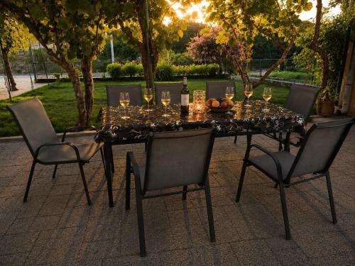 a dining table with wine glasses and chairs at Apartman ODISEJ in Čapljina