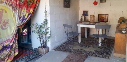 a room with a table and chairs and a plant at Studio cosy à Camembert - 20 m² avec terrasse et parking in Camembert