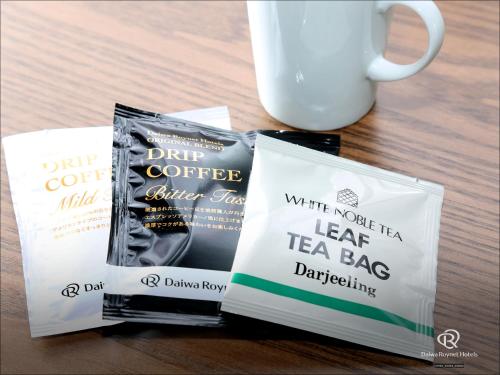 two bags of tea bags next to a cup of coffee at Daiwa Roynet Hotel Tsukuba in Tsukuba