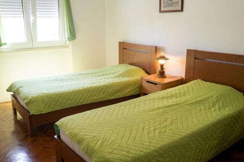 two beds in a room with green sheets at Comfortable Apartment in Feijó with Shared Pool, 90 m² in Almada