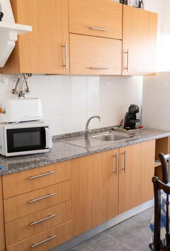 a kitchen with a sink and a microwave at Comfortable Apartment in Feijó with Shared Pool, 90 m² in Almada