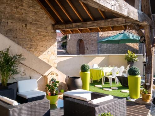 a patio with a table and chairs and an umbrella at Appartement spacieux à Chenevrey-et-Morogne 160 m² avec terrasse in Chenevrey-et-Morogne