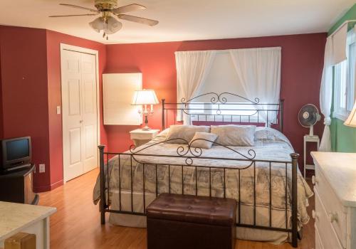 a bedroom with a bed with red walls and a ceiling at Cosy lakeside chalet in Mashteuiatsh with jacuzzi in Mashteuiatsh