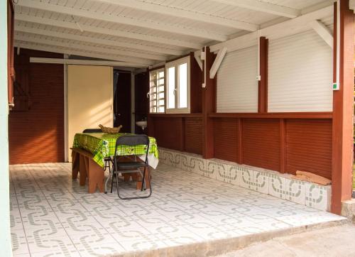 a patio with a table and chairs on a house at Maison charmante Deshaie + Vue in Deshaies