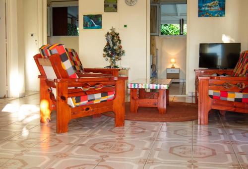 a living room with two chairs and a tv at Maison charmante Deshaie + Vue in Deshaies
