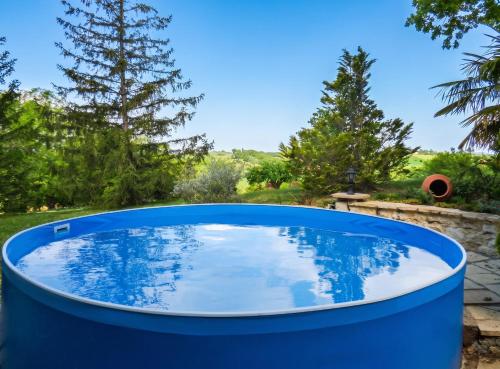 a blue barrel pool in a yard with trees at Appartement avec piscine à Montpezat-de-Quercy 40 m² in Montpezat-de-Quercy