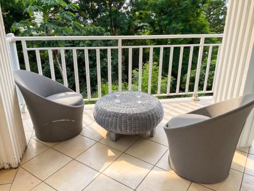 a patio with two chairs and a table on a balcony at Appartement confortable à Deshaies avec vue sur la mer - 55 m² in Deshaies