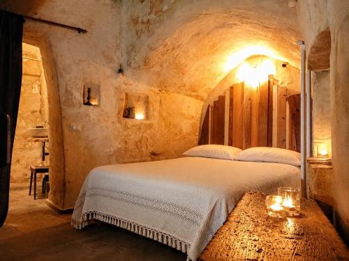 a bedroom with a bed in a stone room at Cave Rooms Sassi in Matera