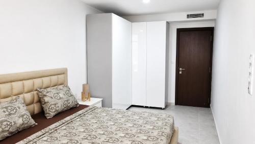 a bedroom with a large bed and a brown door at F3 résidence nid d'abeille in Bejaïa