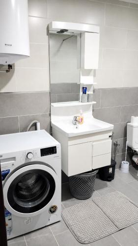 a bathroom with a washing machine and a sink at F3 résidence nid d'abeille in Bejaïa