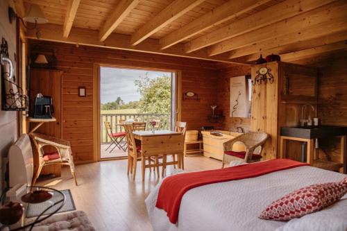 a bedroom with a bed and a desk and a table at Cabane Pomme d'Amour in La Chapelle-Bouexic