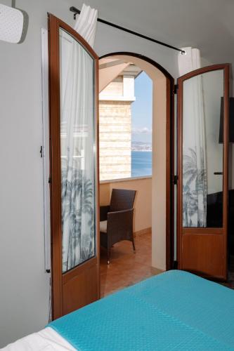 a bedroom with an open door with a view of the ocean at The Square - Luxury Apartment in Scilla