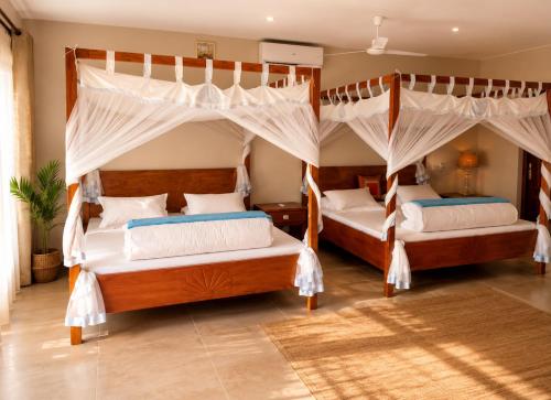a bedroom with two beds with mosquito nets at Villa HASSANI BEACH FOULPOINTE in Foulpointe