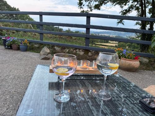 two glasses of wine sitting on a glass table at Hyssington Heights in Hyssington