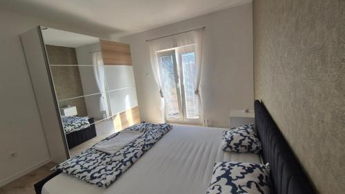 a large bed in a bedroom with a mirror at Apartmani Loli in Ugljan