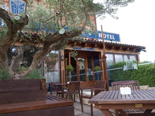 a hotel with tables and chairs in front of a building at Hotel Jakue in Puente la Reina