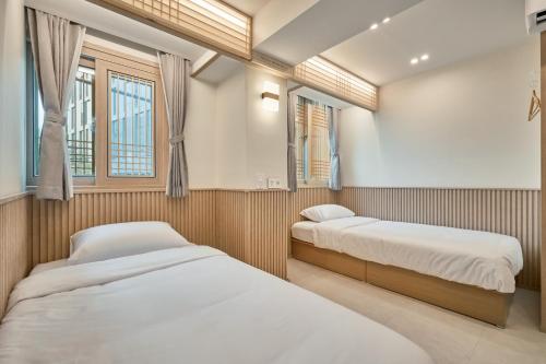 two beds in a small room with two windows at ZIP 1972 DDP two-min from airport bus station 4-min from DDP subway station in Seoul