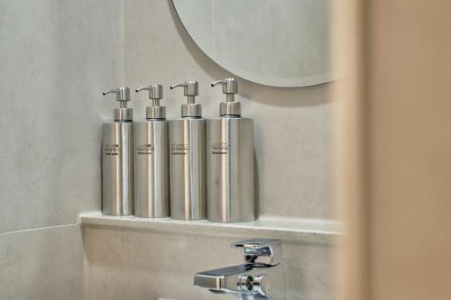 a bathroom with a mirror and a sink with silver pipes at ZIP 1972 DDP two-min from airport bus station 4-min from DDP subway station in Seoul
