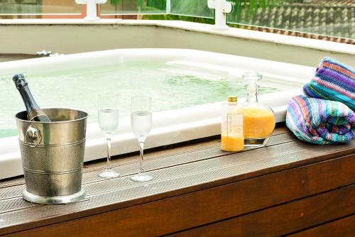 a bath tub with glasses and bottles of wine at Louise village in Juquei
