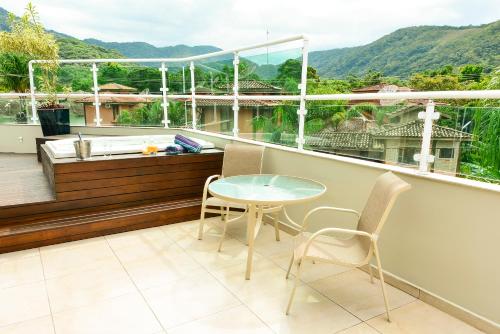 a balcony with a table and chairs and a tub at Louise village in Juquei
