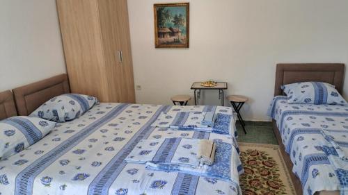 a bedroom with two beds with blue and white sheets at Apartmani Stanić in Sutomore