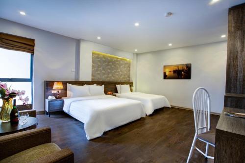 um quarto de hotel com duas camas e uma mesa e um sofá em My Linh Hotel em Hanói