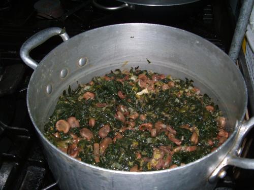 a pot filled with mushrooms and greens on a stove at Hotel Piccolo Paradiso in Peschici